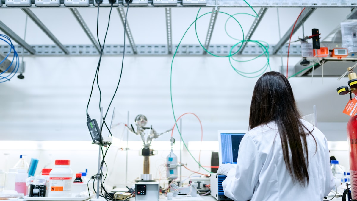 A researcher in a lab coat working at a science lab bench
