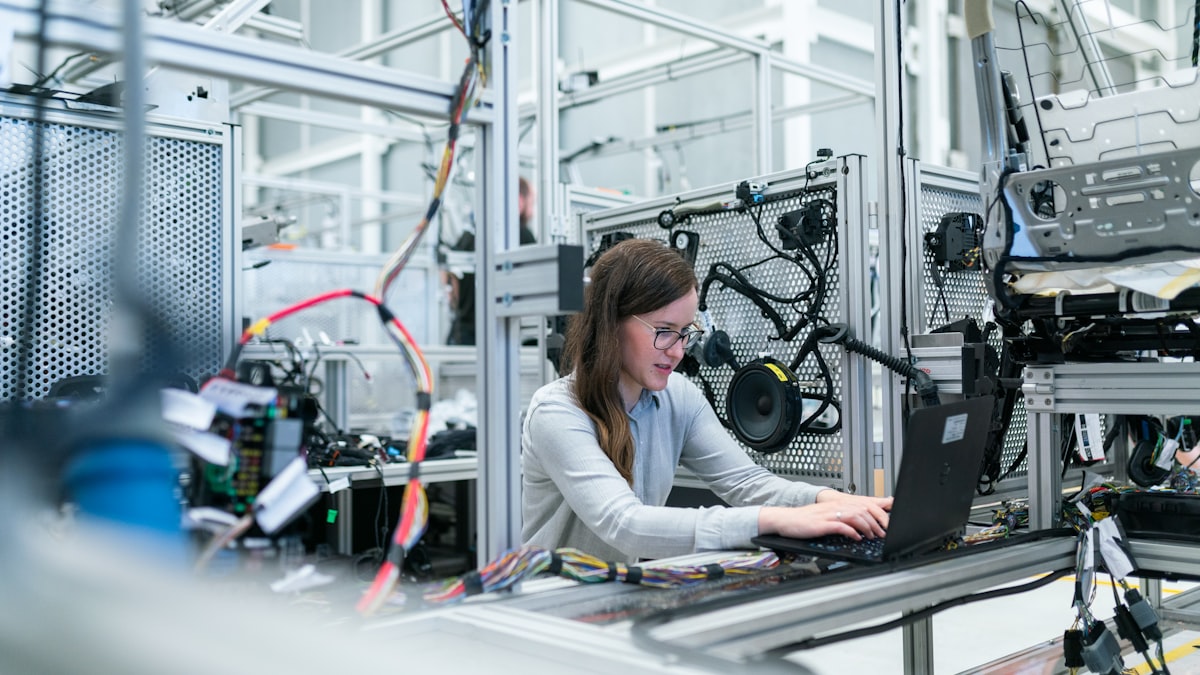 A mechanical engineer working on a laptop in a hardware lab